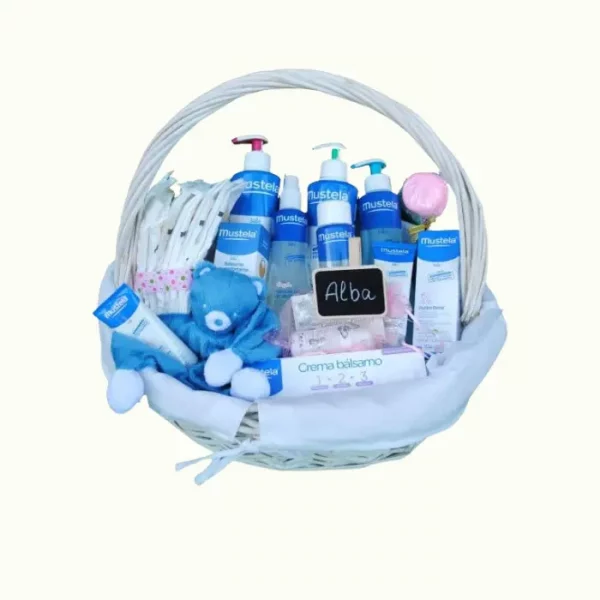 Cesta de nacimiento extra Catalina Lunares con productos Mustela, pañales, dou dou y más. Presentada en cesta blanca de mimbre sin asa, con envoltorio para regalo y pizarra personalizada con el nombre del bebé. Un regalo completo, práctico y lleno de cariño.